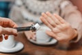 Woman in cafe refuses a piece of white sugar for her tea. Say no to sugar and fast carbs. Diet for diabetes and addiction to