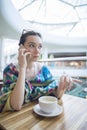 A woman in a cafe is talking on the phone. Royalty Free Stock Photo