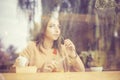 Woman at cafe thinking happy and smiling. cross-processed retro style image Royalty Free Stock Photo