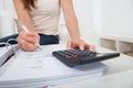 Woman calculating home finances at table