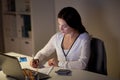 Woman with calculator and papers at night office Royalty Free Stock Photo