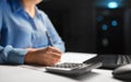 Woman with calculator and papers at night office Royalty Free Stock Photo