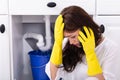 Woman Calling Plumber In Front Of Water Leaking From Pipe Royalty Free Stock Photo