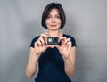 Woman with  camera. Everyday clothes. Gray background.  Gopro. Action camera Royalty Free Stock Photo