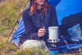 Woman camping and cooking with portable stove