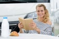 woman on camping holiday reading book at breakfast Royalty Free Stock Photo