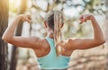 Woman can flex too. a young woman flexing her arms outdoors.