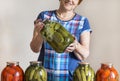 Woman with a can of pickled cucumbers, jars of pickles, salted,