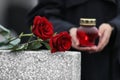 Woman with candle, focus on red roses. Funeral ceremony Royalty Free Stock Photo