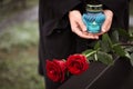 Woman with candle, focus on red roses. Funeral ceremony Royalty Free Stock Photo