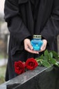 Woman with candle outdoors, focus on roses. Funeral ceremony Royalty Free Stock Photo