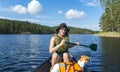 Woman canoeing on the lake with dog Royalty Free Stock Photo