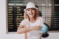 Woman in Cap with Globe in Airport in Waiting Room
