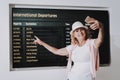Woman in Cap with Phone in Airport in Waiting Room