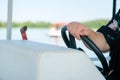 Woman captain holding the steering wheel in a boat. Summer time vacation with sailboat in an open waters, female captain in a Royalty Free Stock Photo