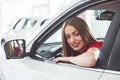 Woman in car indoor keeps wheel turning around smiling looking at passengers in back seat idea taxi driver against Royalty Free Stock Photo