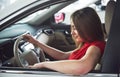 Woman in car indoor keeps wheel turning around smiling looking at passengers in back seat idea taxi driver against Royalty Free Stock Photo