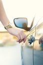 Woman with car key. Opening car door. WomanÃÂ´s hand unlocking a door on a car. Sunlight. Transportation.