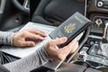 Woman in the car with laptop and american passport. Travel concept. Royalty Free Stock Photo