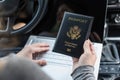 Woman in the car with laptop and american passport. Travel concept. Royalty Free Stock Photo