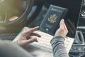 Woman in the car with laptop and american passport. Travel concept. Royalty Free Stock Photo