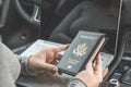 Woman in the car with laptop and american passport. Travel concept. Royalty Free Stock Photo