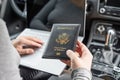 Woman in the car with laptop and american passport. Travel concept. Royalty Free Stock Photo