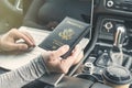 Woman in the car with laptop and american passport. Travel concept. Royalty Free Stock Photo