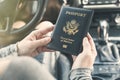 Woman in the car with laptop and american passport. Travel concept. Royalty Free Stock Photo