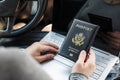 Woman in the car with laptop and american passport. Travel concept. Royalty Free Stock Photo