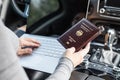 Woman in the car with laptop and germany passport. Travel concept. Royalty Free Stock Photo