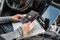 Woman in the car with laptop and germany passport. Travel concept. Royalty Free Stock Photo