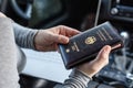 Woman in the car with laptop and germany passport. Travel concept. Royalty Free Stock Photo