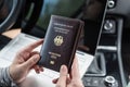 Woman in the car with laptop and germany passport. Travel concept. Royalty Free Stock Photo