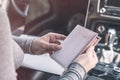 Woman in the car with laptop and passport in a pink cover. Travel concept. Royalty Free Stock Photo