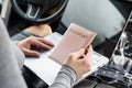 Woman in the car with laptop and passport in a pink cover. Travel concept. Royalty Free Stock Photo