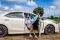 Woman in a car looking at a map to reach the holiday destination with blue sky Royalty Free Stock Photo