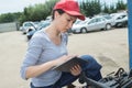 Woman car mechanician repairs engine car outdoors