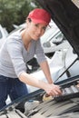 Woman car mechanician repairs engine car and smiles