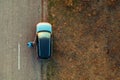 Woman and car on road through grassy wastelands, aerial view Royalty Free Stock Photo