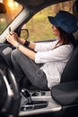 Woman in the car. Smiling girl listening to music on your smartphone with headphones Royalty Free Stock Photo