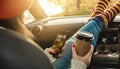 Woman in a car in warm socks is holding a mobile phone gadget at sunset. Cozy autumn weekend trip. Freedom of travel Royalty Free Stock Photo