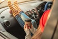 Woman in a car in warm socks yellow is holding a Cup of coffee in hands at sunset. Cozy autumn weekend trip Royalty Free Stock Photo