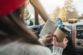 Woman in a car in warm woolen socks yellow is reading a book at sunset. Cozy autumn weekend trip. Freedom of travel Royalty Free Stock Photo