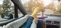 Woman in a car in warm woolen yellow socks on the car dashboard. Cozy autumn weekend trip. Concept of freedom of travel Royalty Free Stock Photo