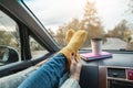 Woman in a car in warm woolen yellow socks on the car dashboard. Cozy autumn weekend trip. Concept of freedom of travel Royalty Free Stock Photo