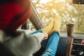 Woman in a car in warm woolen yellow socks on the car dashboard. Cozy autumn weekend trip. Concept of freedom of travel Royalty Free Stock Photo