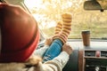 Woman in a car in warm woolen yellow socks on the car dashboard. Cozy autumn weekend trip. Concept of freedom of travel Royalty Free Stock Photo