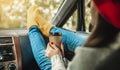 Woman in a car in warm yellow socks is holding a Cup of coffee in hands. Cozy autumn weekend trip. Freedom of travel Royalty Free Stock Photo
