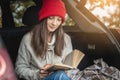 Woman in a car in warm woolen yellow socks is reading a book. Cozy autumn weekend trip. The concept of freedom of travel Royalty Free Stock Photo